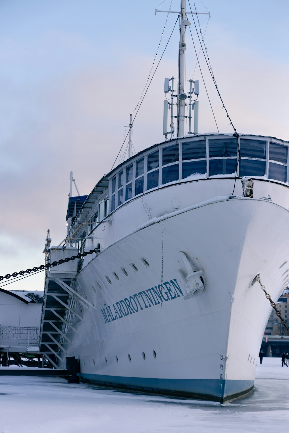 a large white boat sitting on top of snow covered ground