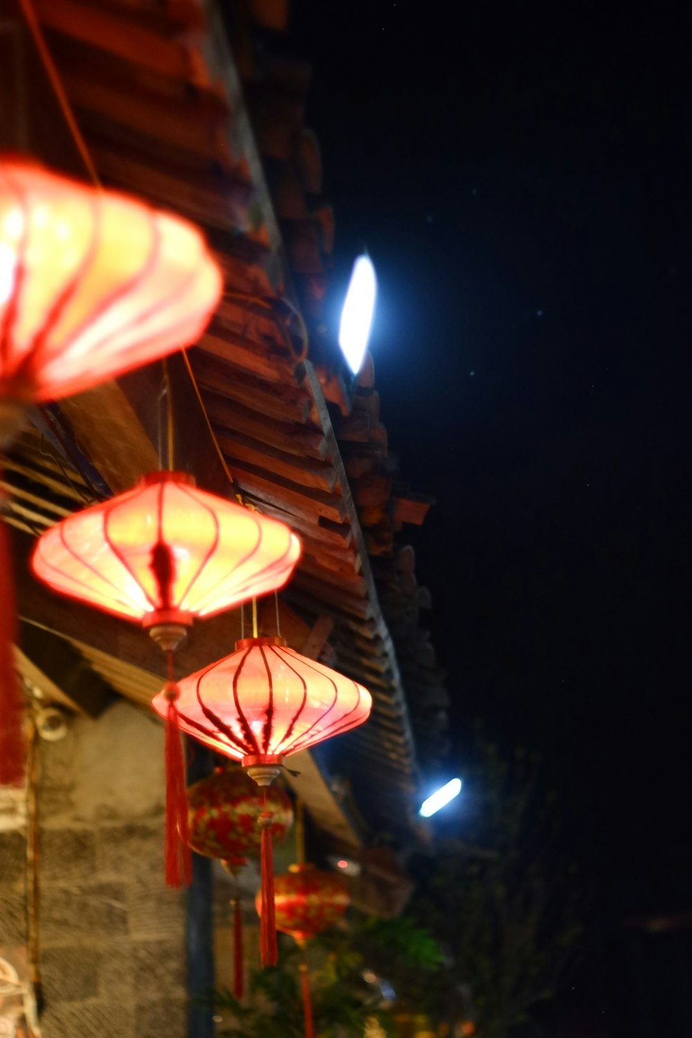 a row of red lanterns hanging from the side of a building