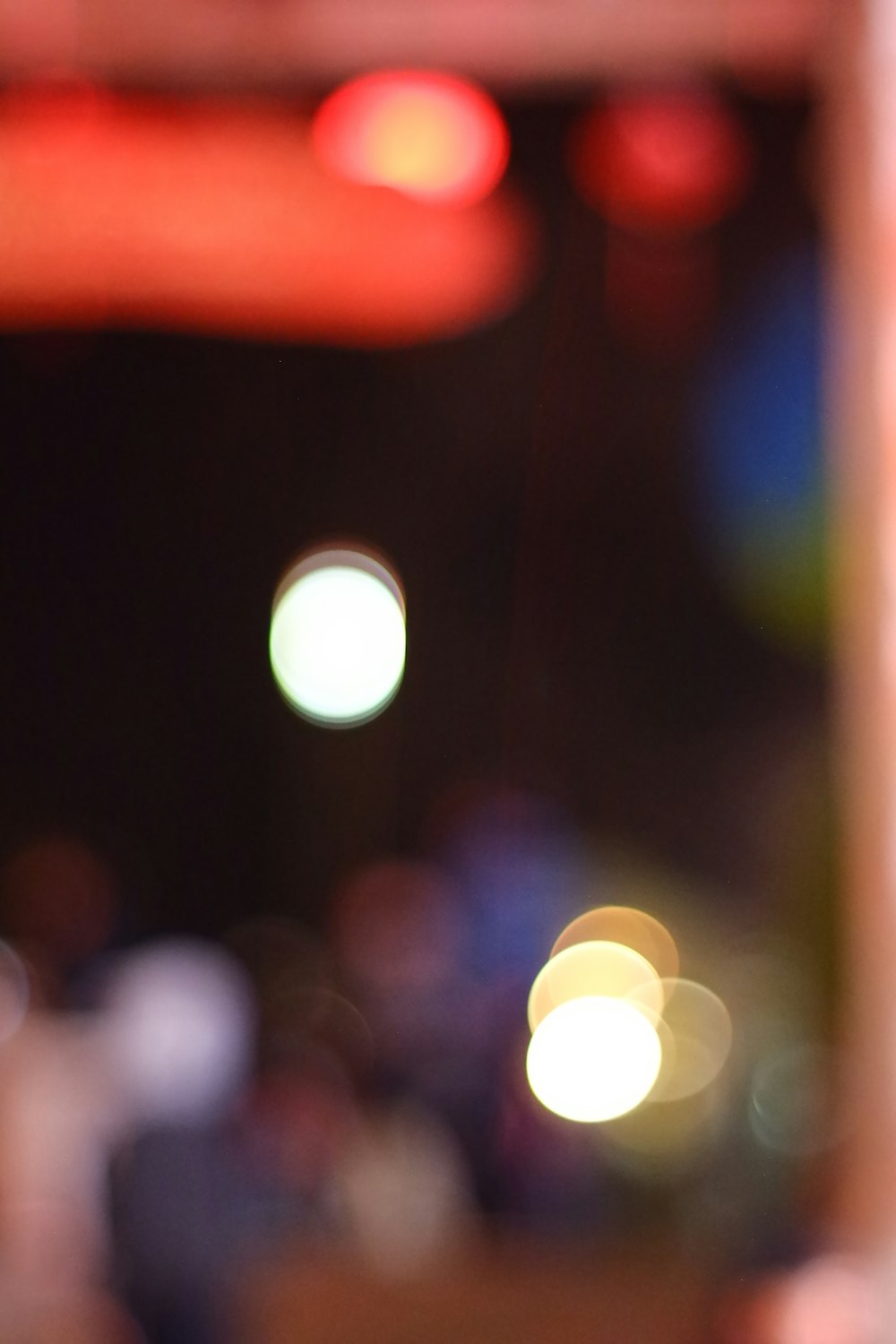 a close up of a cell phone with blurry lights in the background