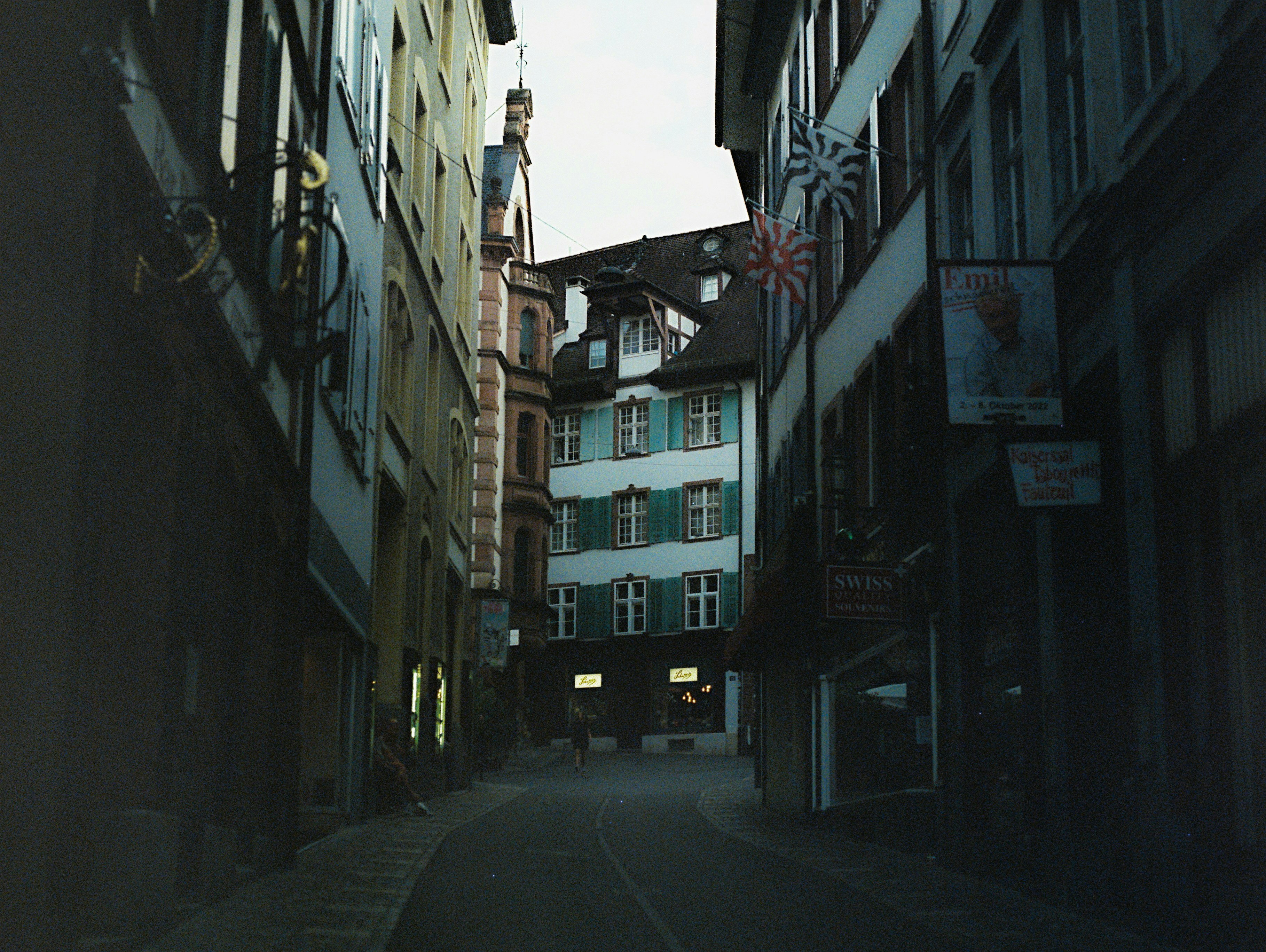eine schmale Stadtstraße mit einem Glockenturm im Hintergrund