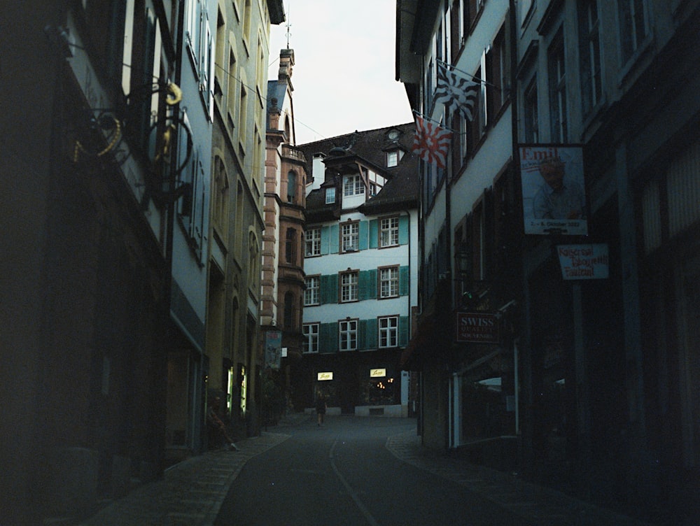 a narrow city street with a clock tower in the background