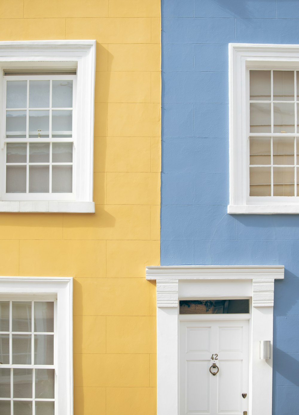 a blue and yellow house with a white door