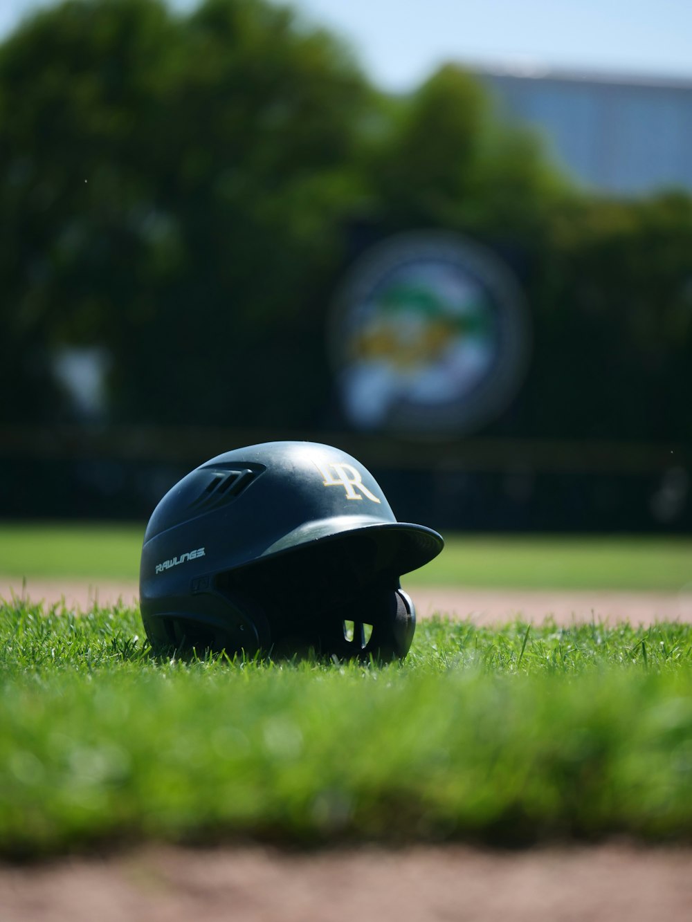 a baseball helmet sitting on top of a green field