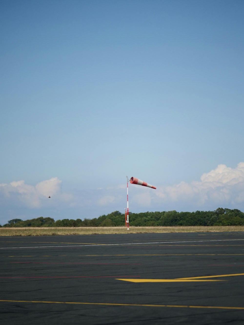a red and white flag on a pole in an airport