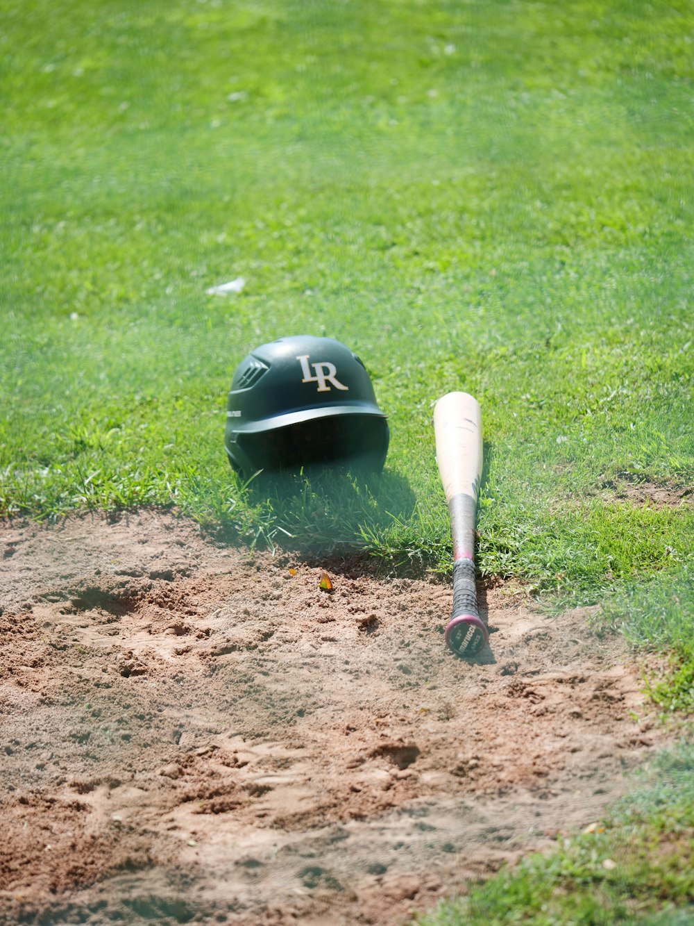 a baseball bat and a helmet on a field