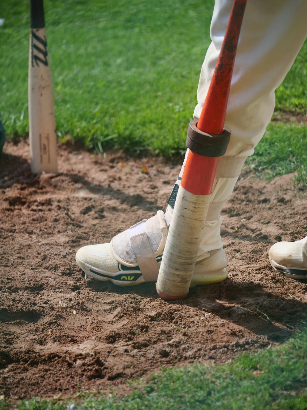 a baseball player standing next to a baseball bat