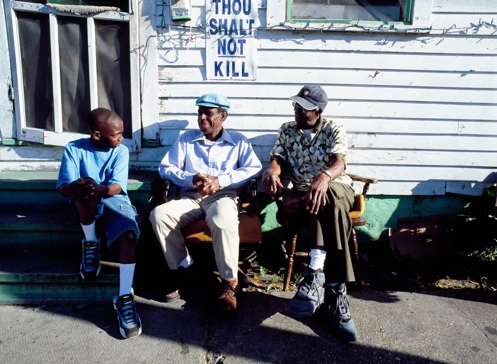 Friends relax in front of a home that carries a message in New Orleans