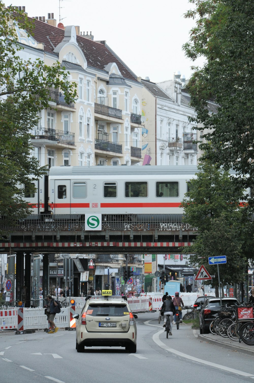 a car driving down a street next to a train