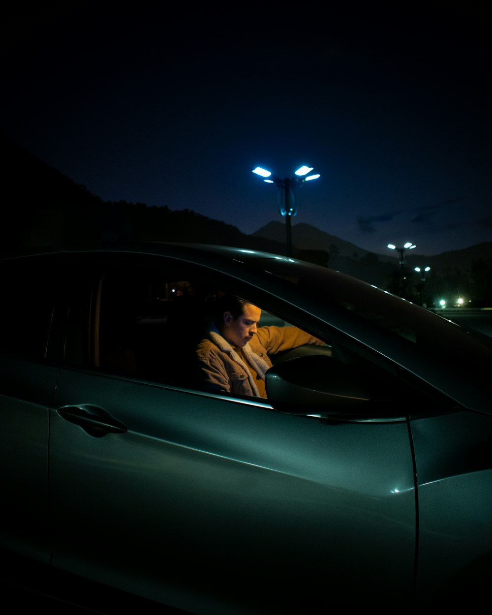 a man sitting in a car at night