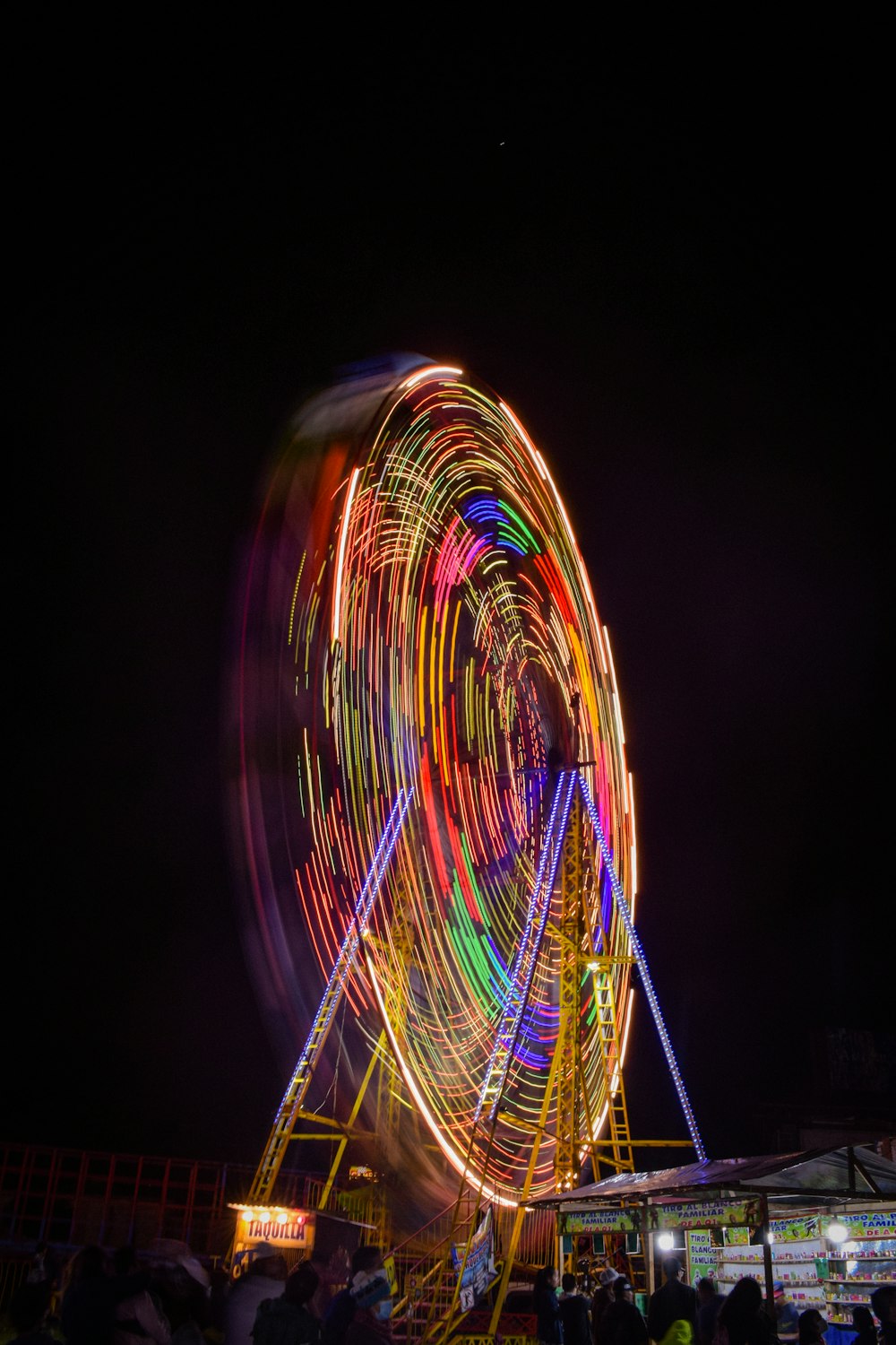 Una ruota panoramica di notte con un sacco di luci