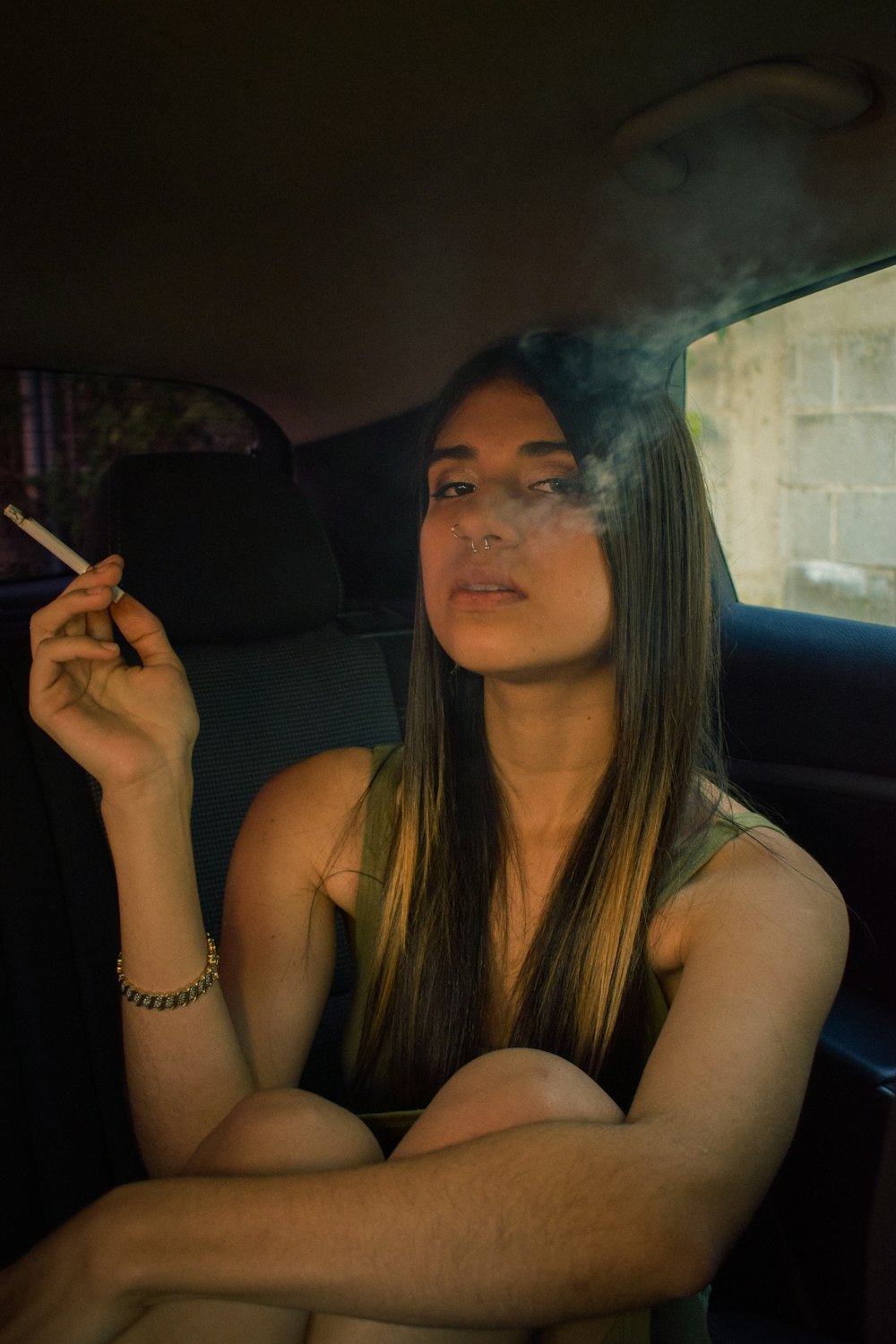 a woman smoking a cigarette in a car