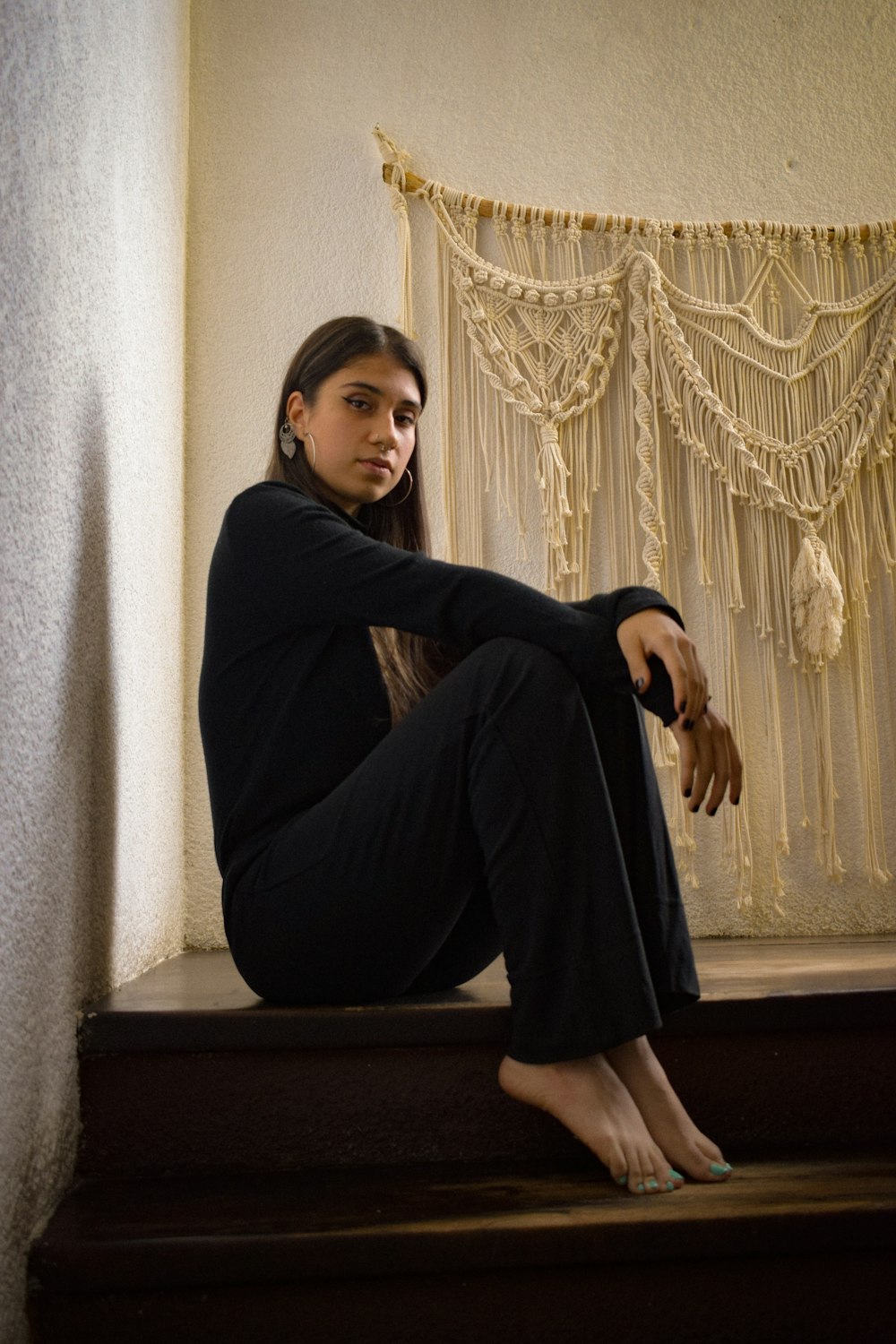 a woman sitting on a step in front of a curtain