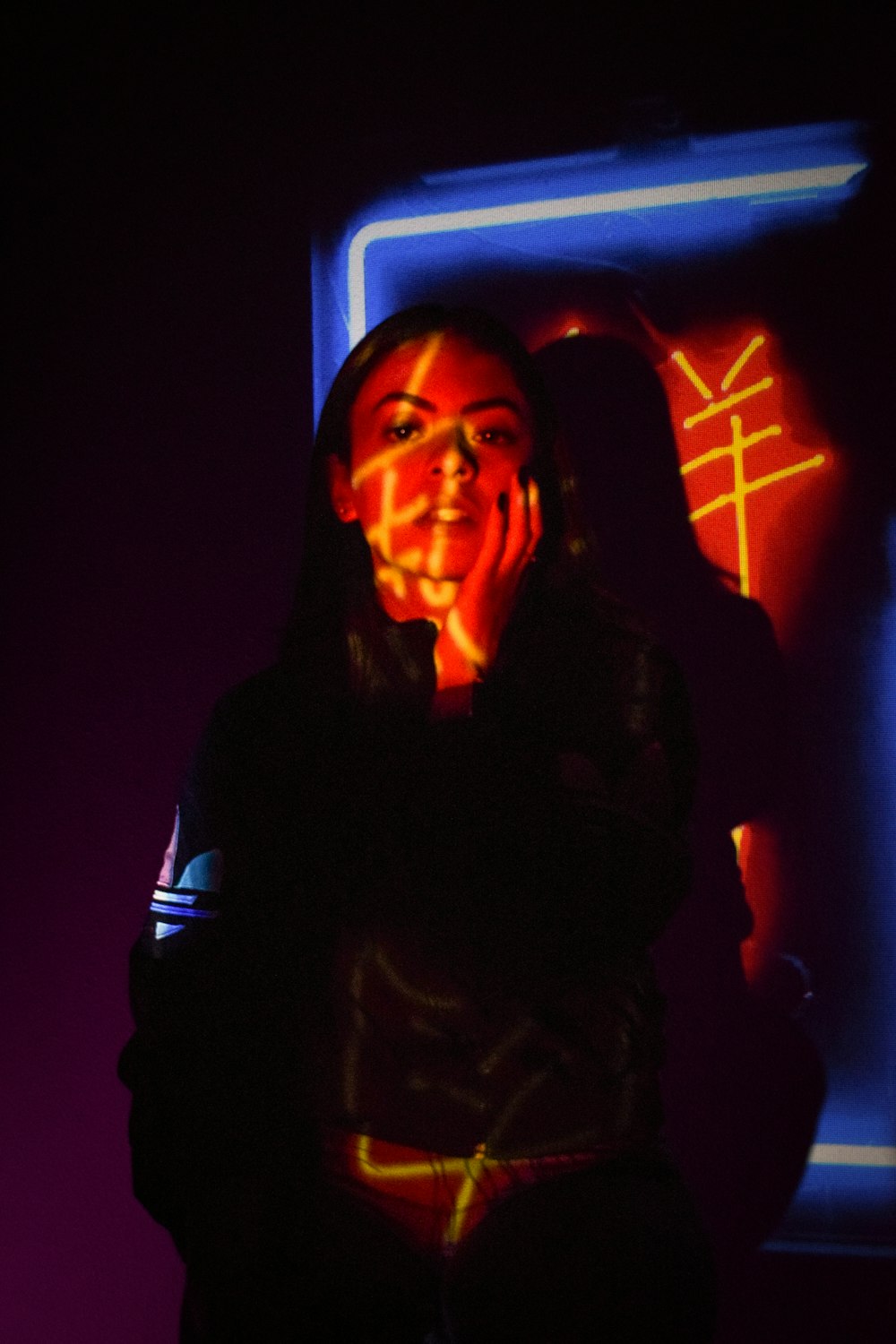 a woman standing in front of a neon sign