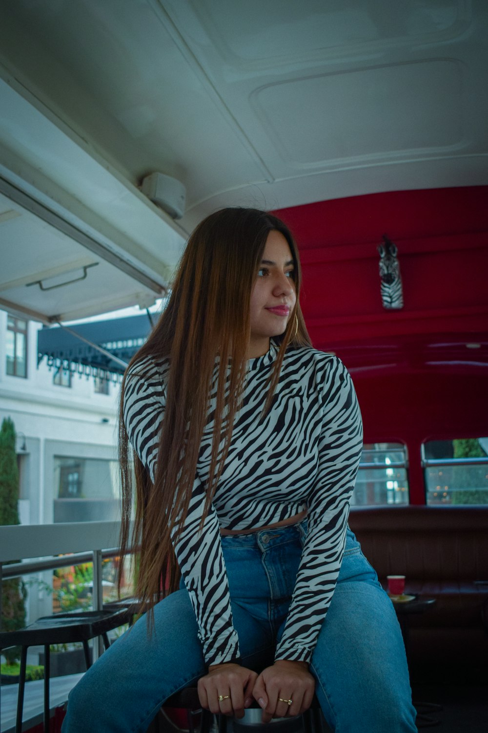 a woman with long hair sitting on a bench