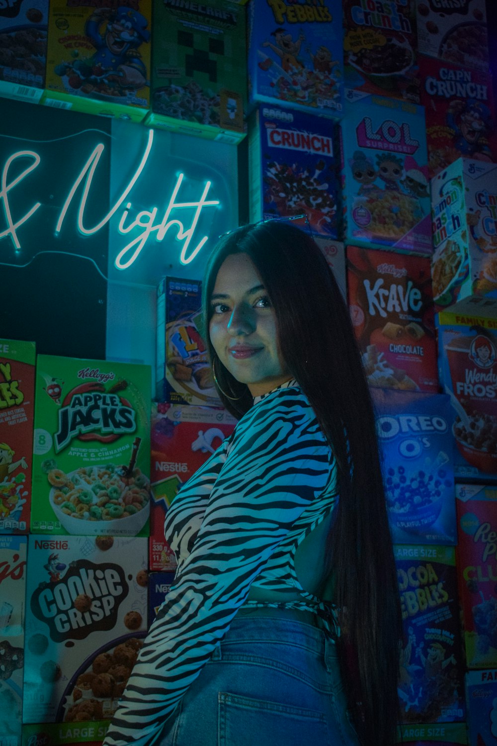 a woman standing in front of a neon sign