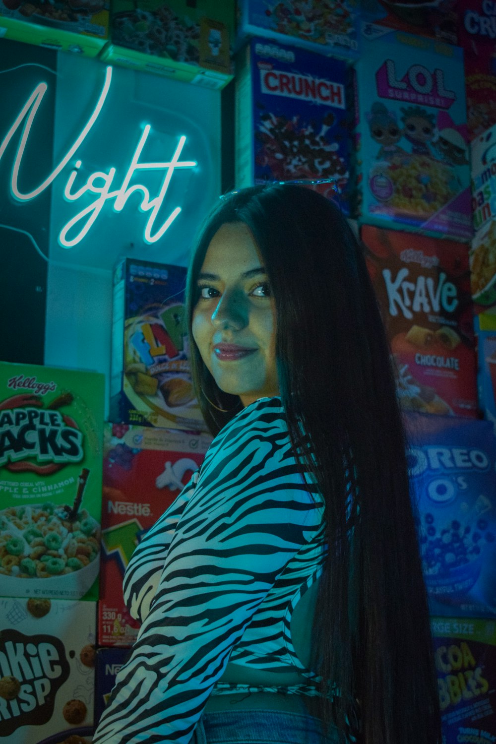 a woman standing in front of a neon sign