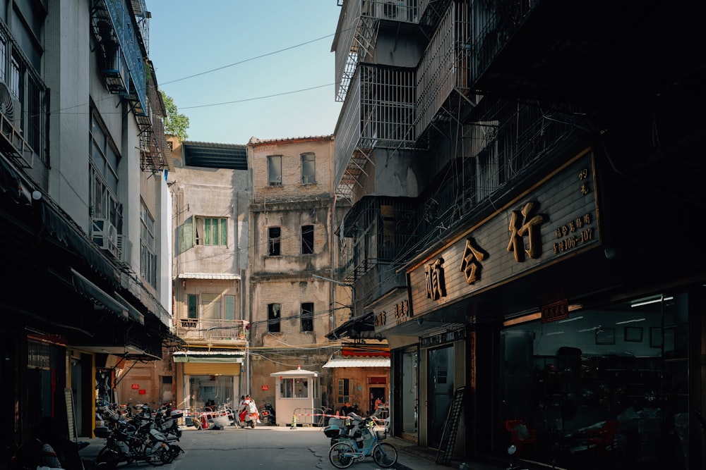 a narrow city street with motorcycles parked on both sides