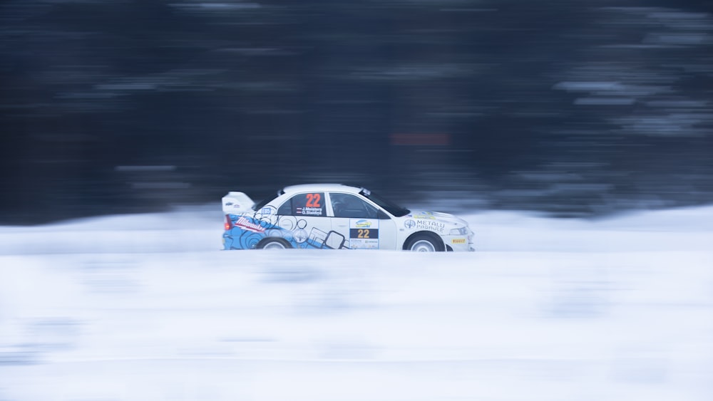 a white car driving down a snow covered road