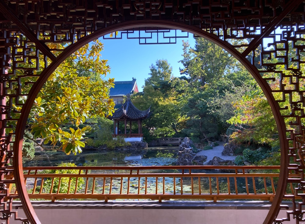 Una vista de un jardín a través de una ventana circular