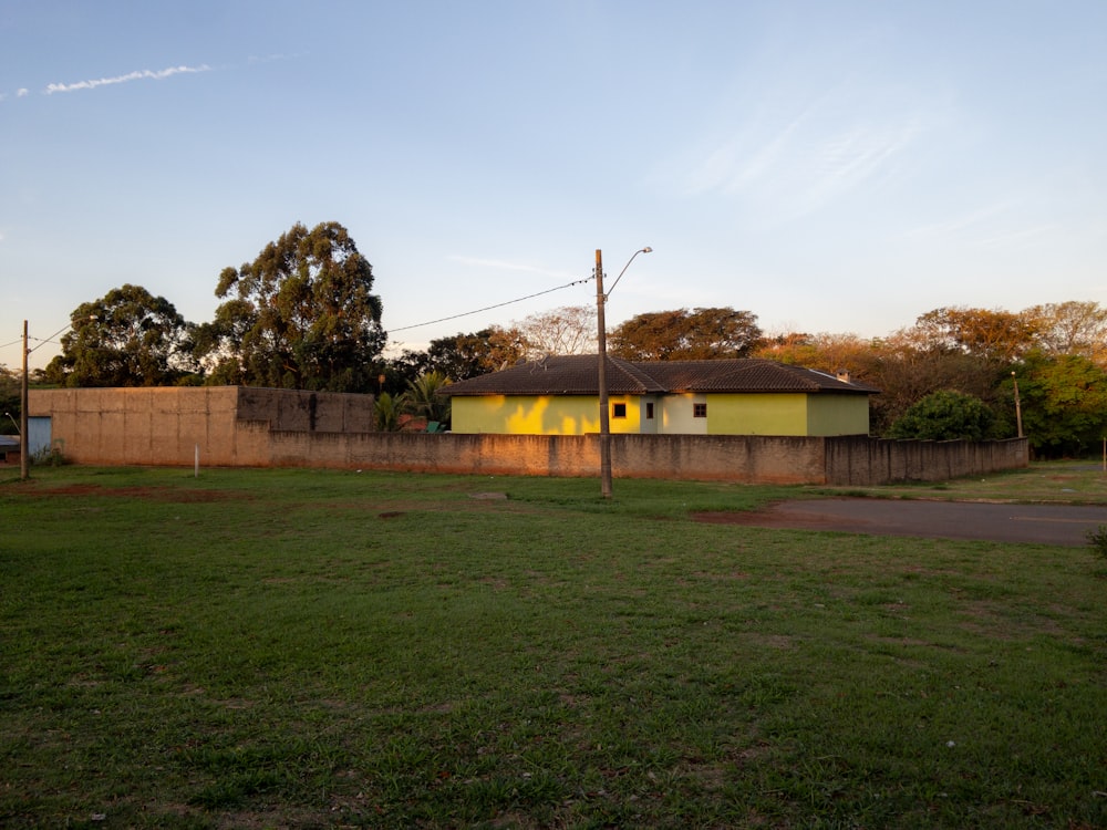 a small yellow building in a grassy field