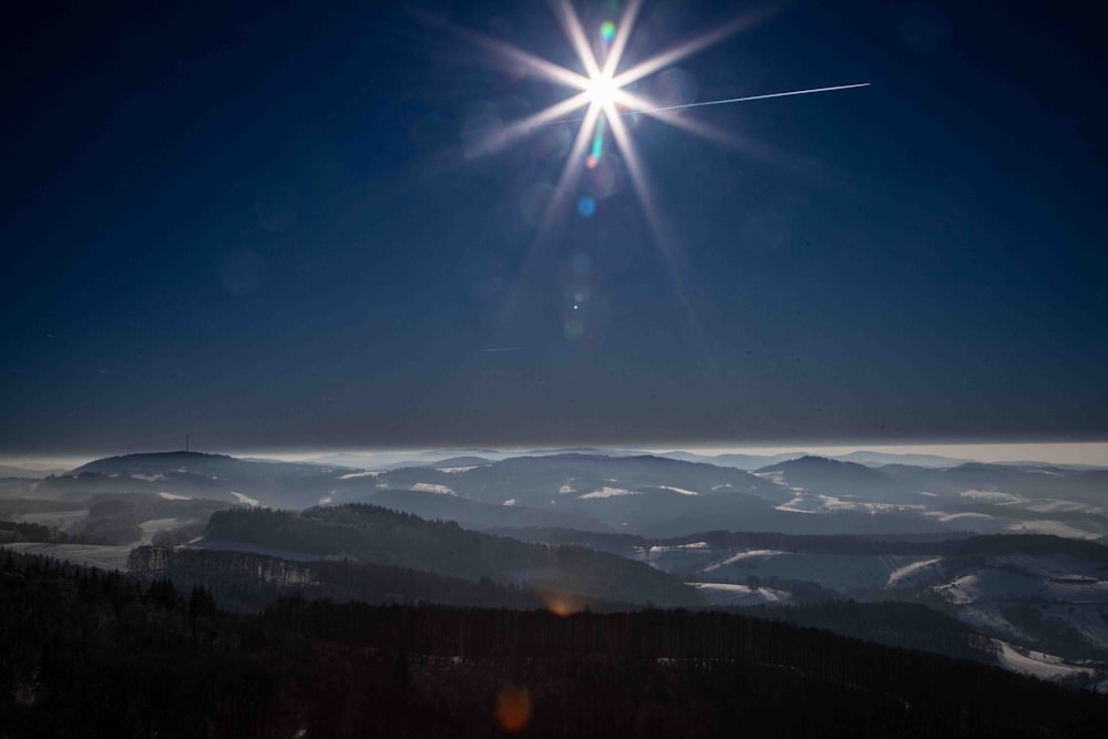 the sun shines brightly over a mountain range