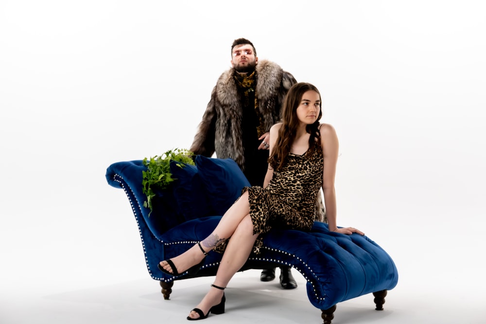 a woman sitting on a blue chair next to a man