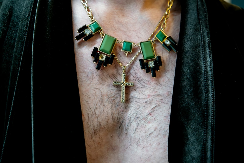 a close up of a person wearing a necklace with a cross on it