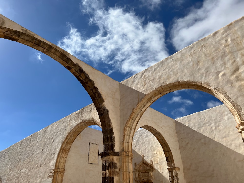 an arch in a building with a blue sky in the background