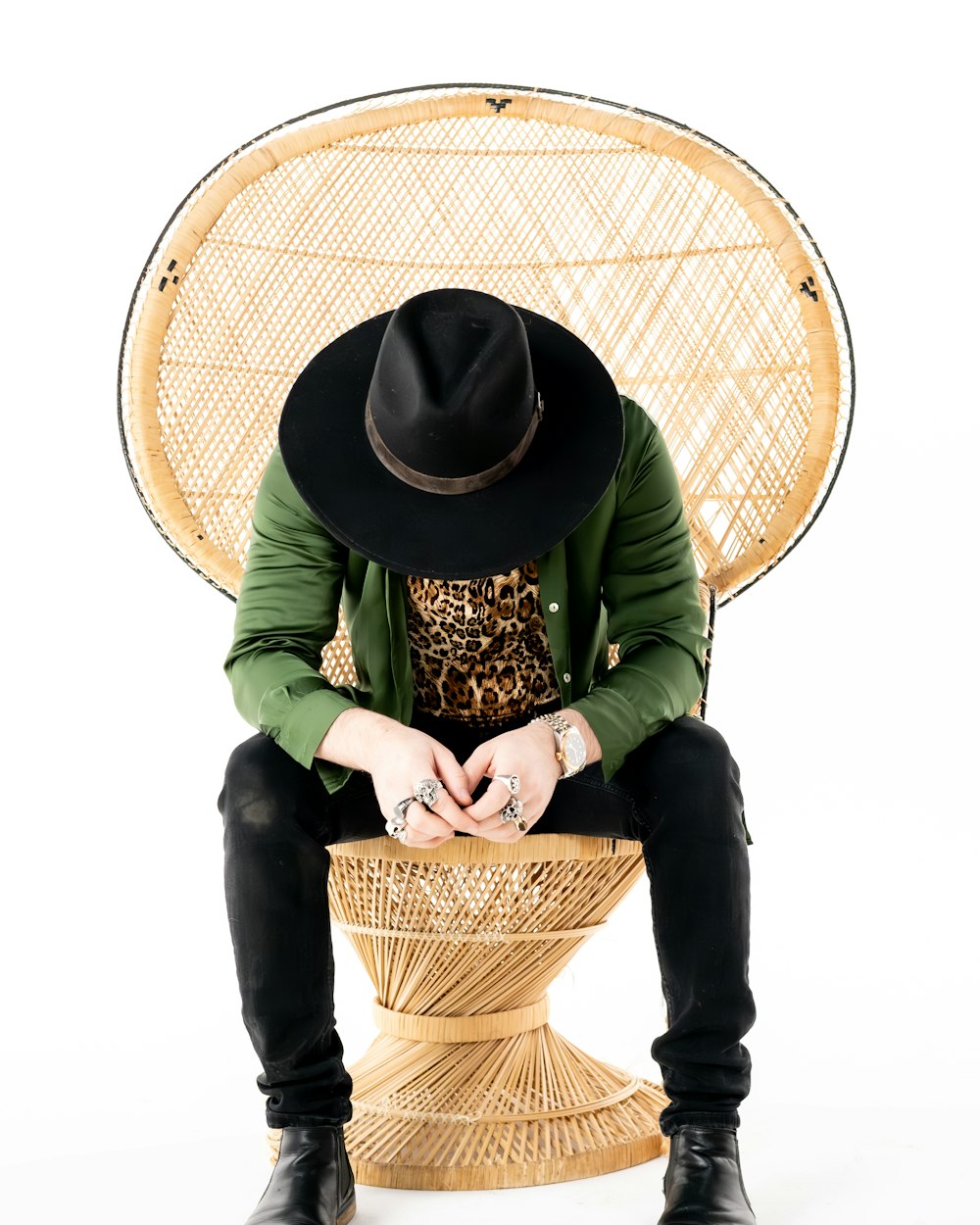 a man sitting on a chair with a hat on