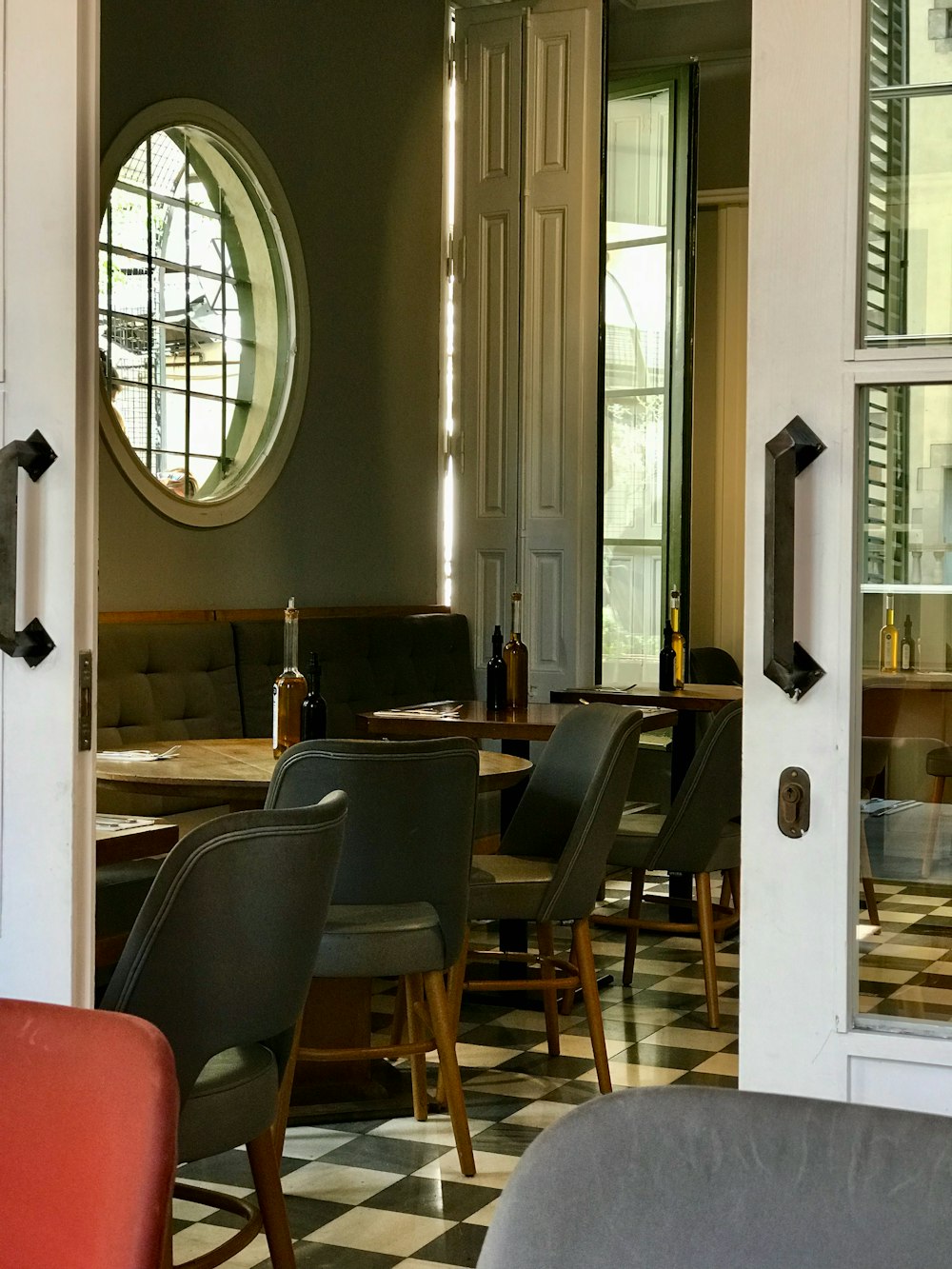 a dining room with a checkered floor and a round window