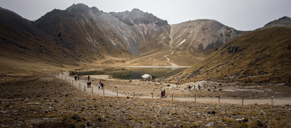 a group of people walking on a path in the mountains