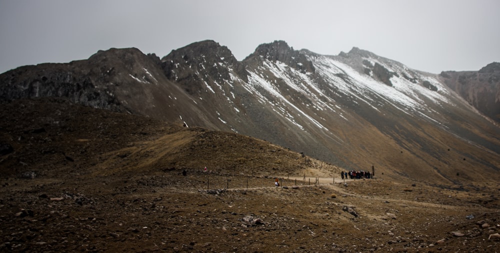 a group of people walking up a mountain side