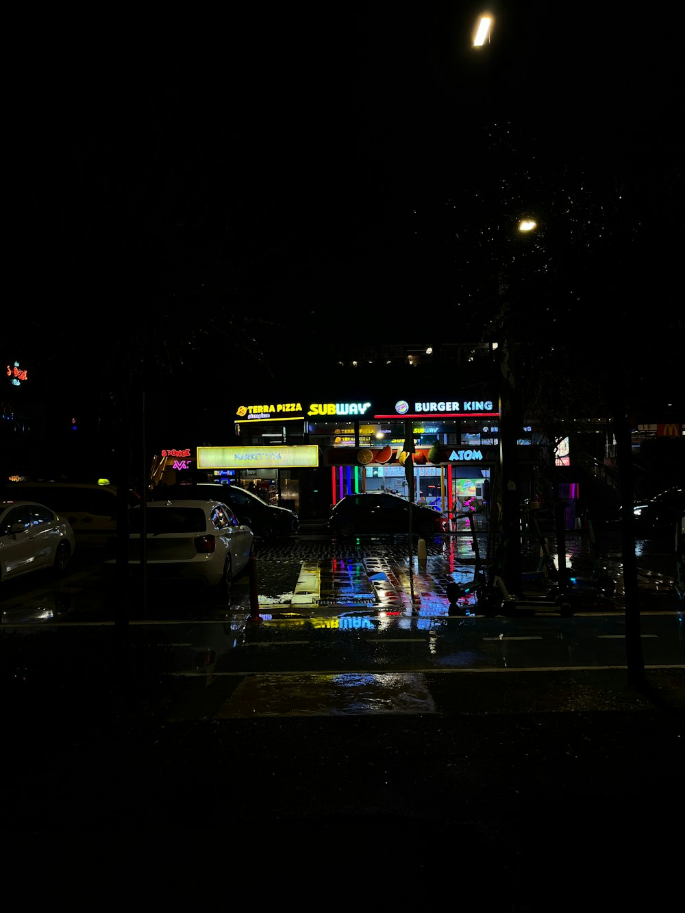 a person holding an umbrella in the rain at night