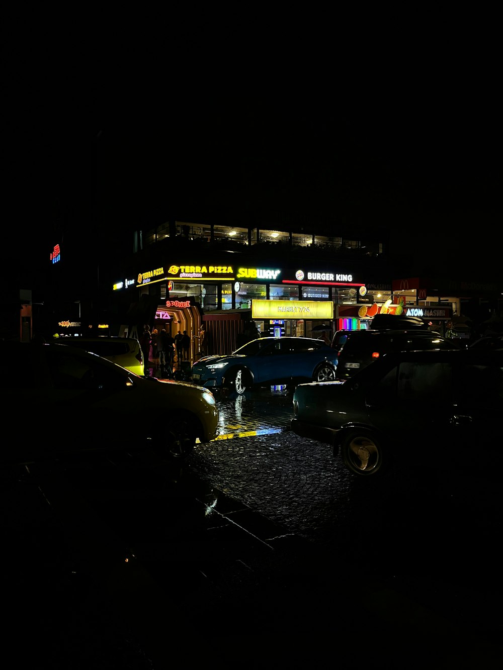 a car parked in front of a building at night