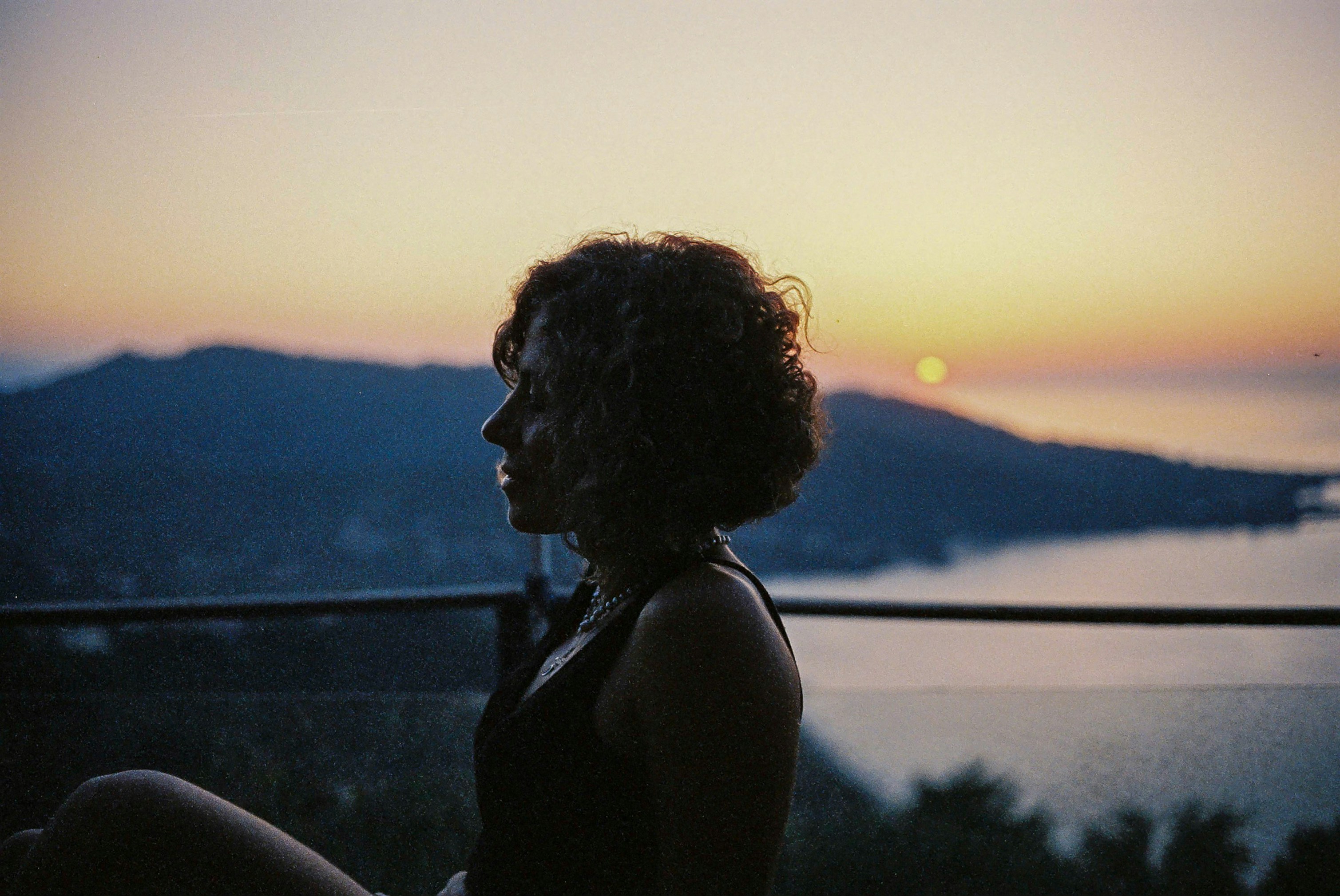 A person looking thoughtfully at a sunset, inspired by a movie.