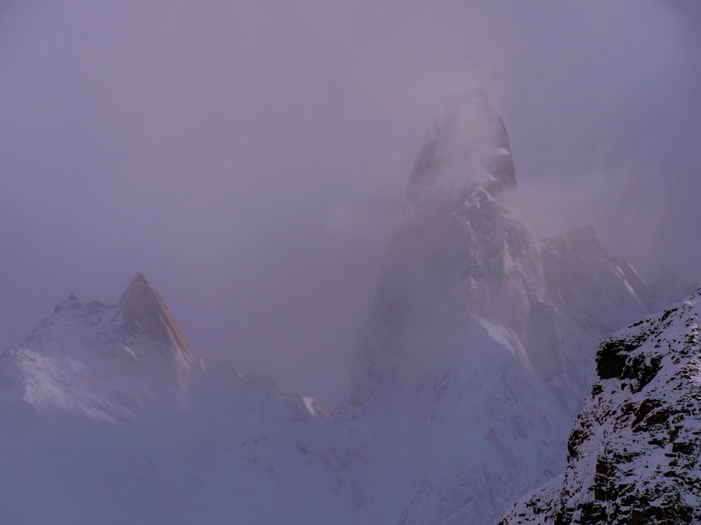 a very tall mountain covered in snow on a cloudy day