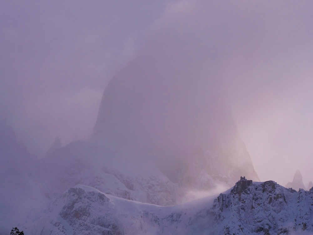 a mountain covered in snow with a cloud in the sky