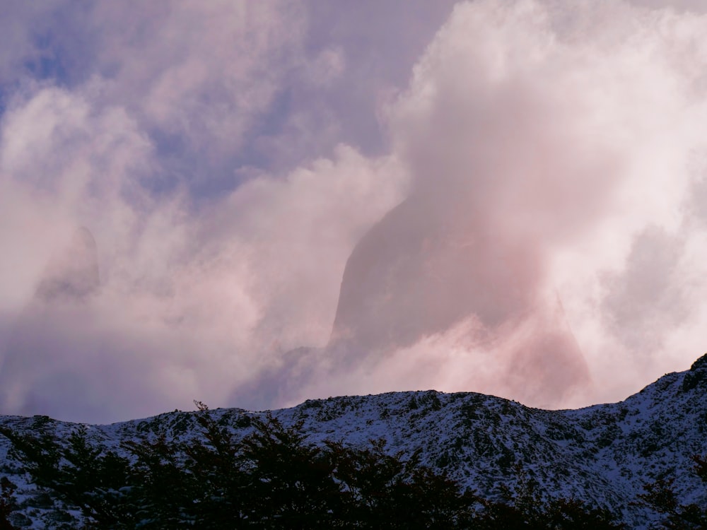 una montagna coperta di neve sotto un cielo nuvoloso