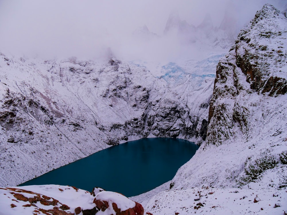 a snow covered mountain with a lake in the middle