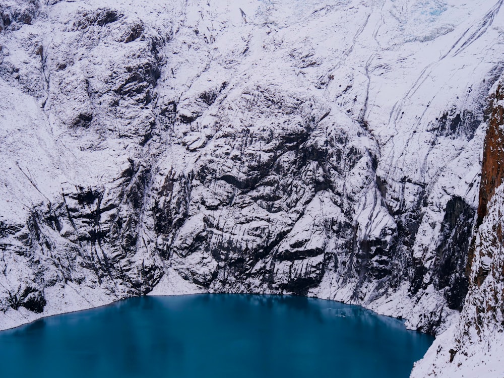 a large body of water surrounded by snow covered mountains