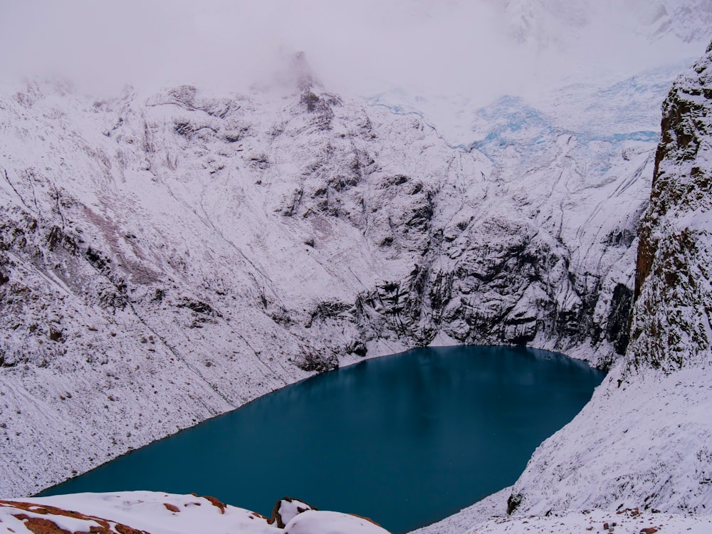 a snow covered mountain with a lake in the middle