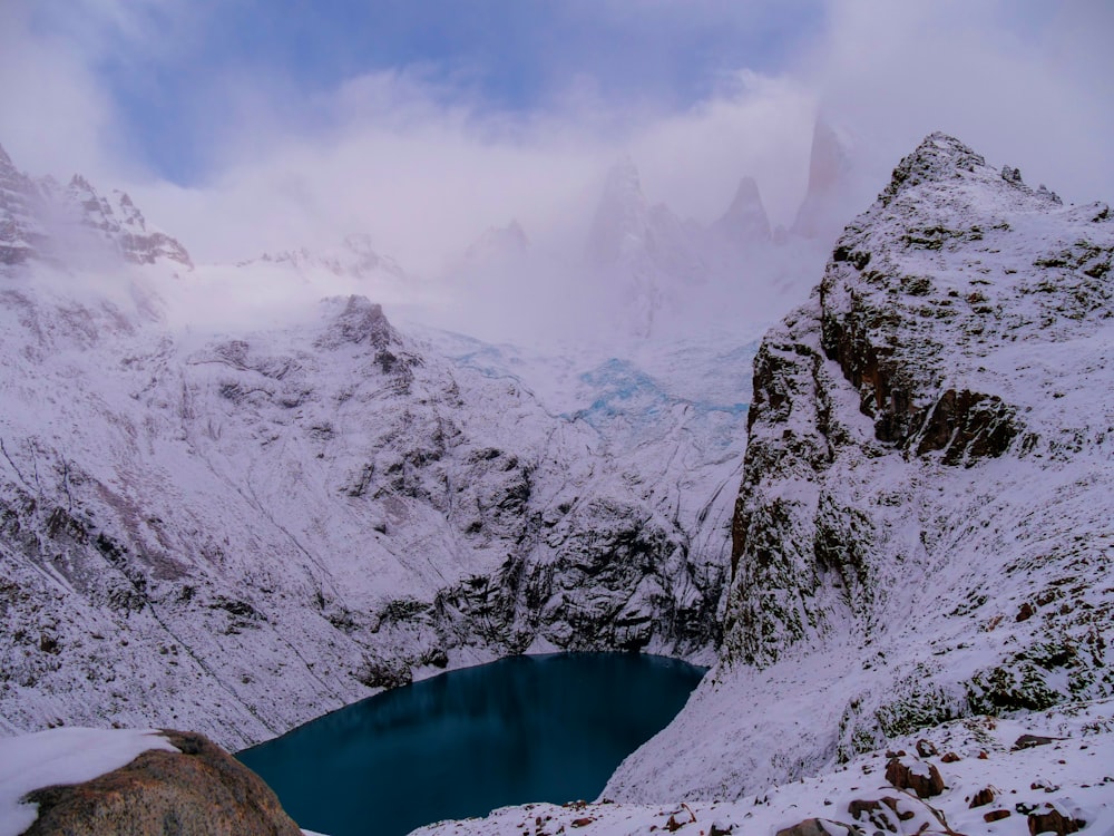 a snow covered mountain with a lake in the middle