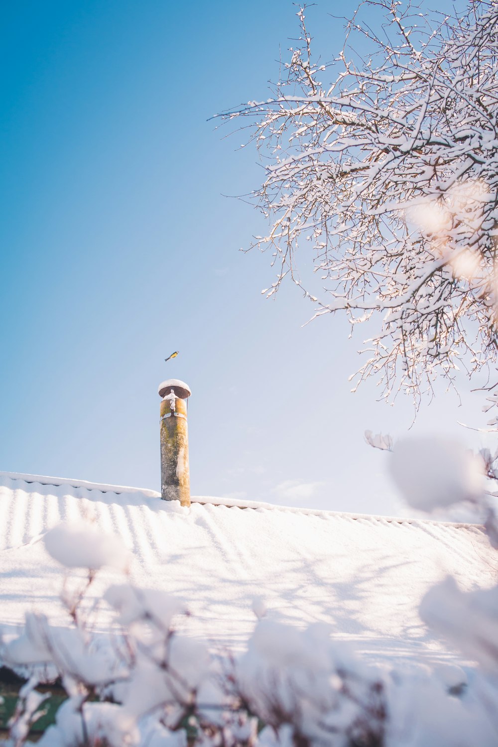 a tall tower sitting on top of a snow covered roof