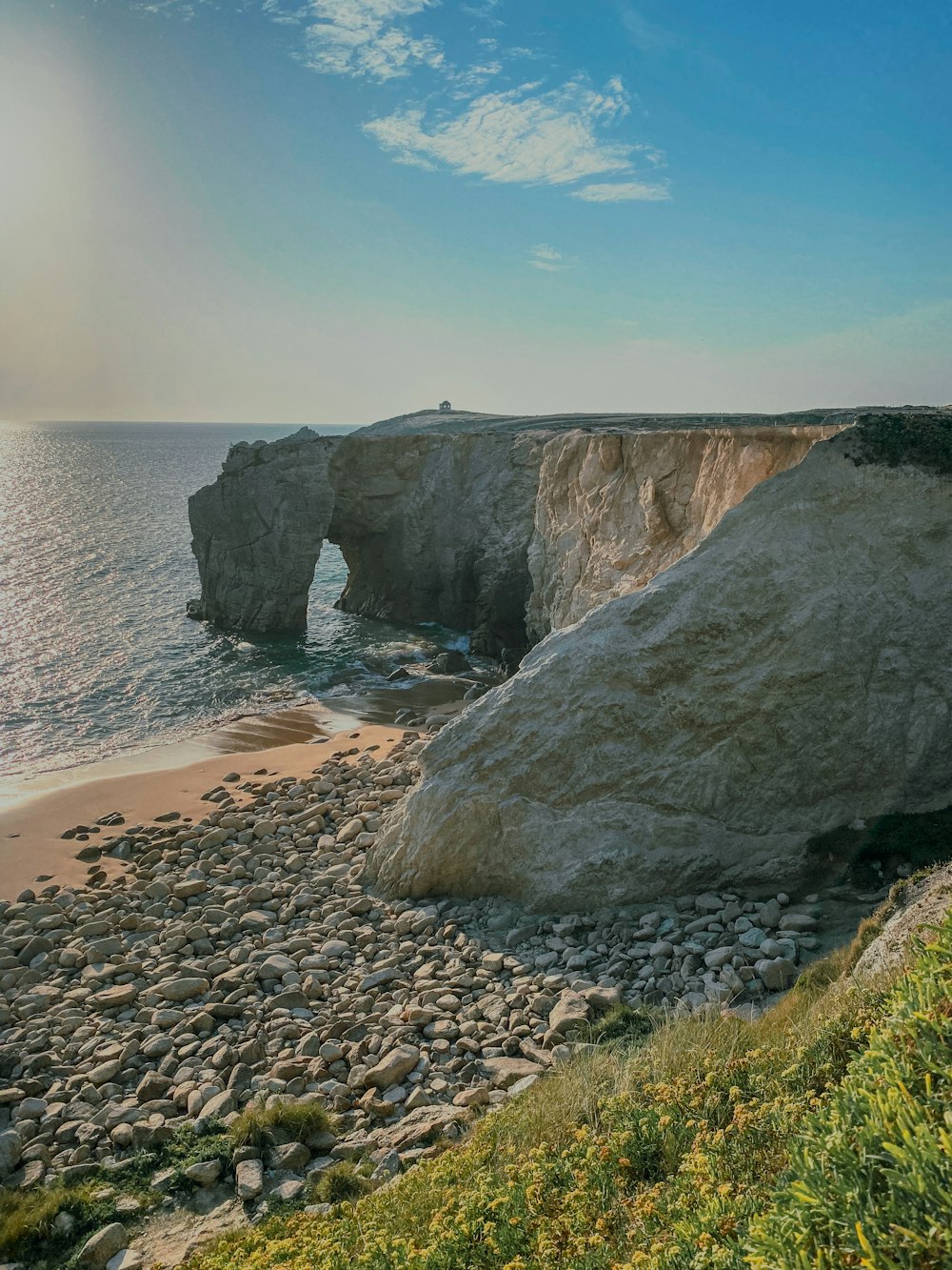 a rocky beach next to a large rock formation