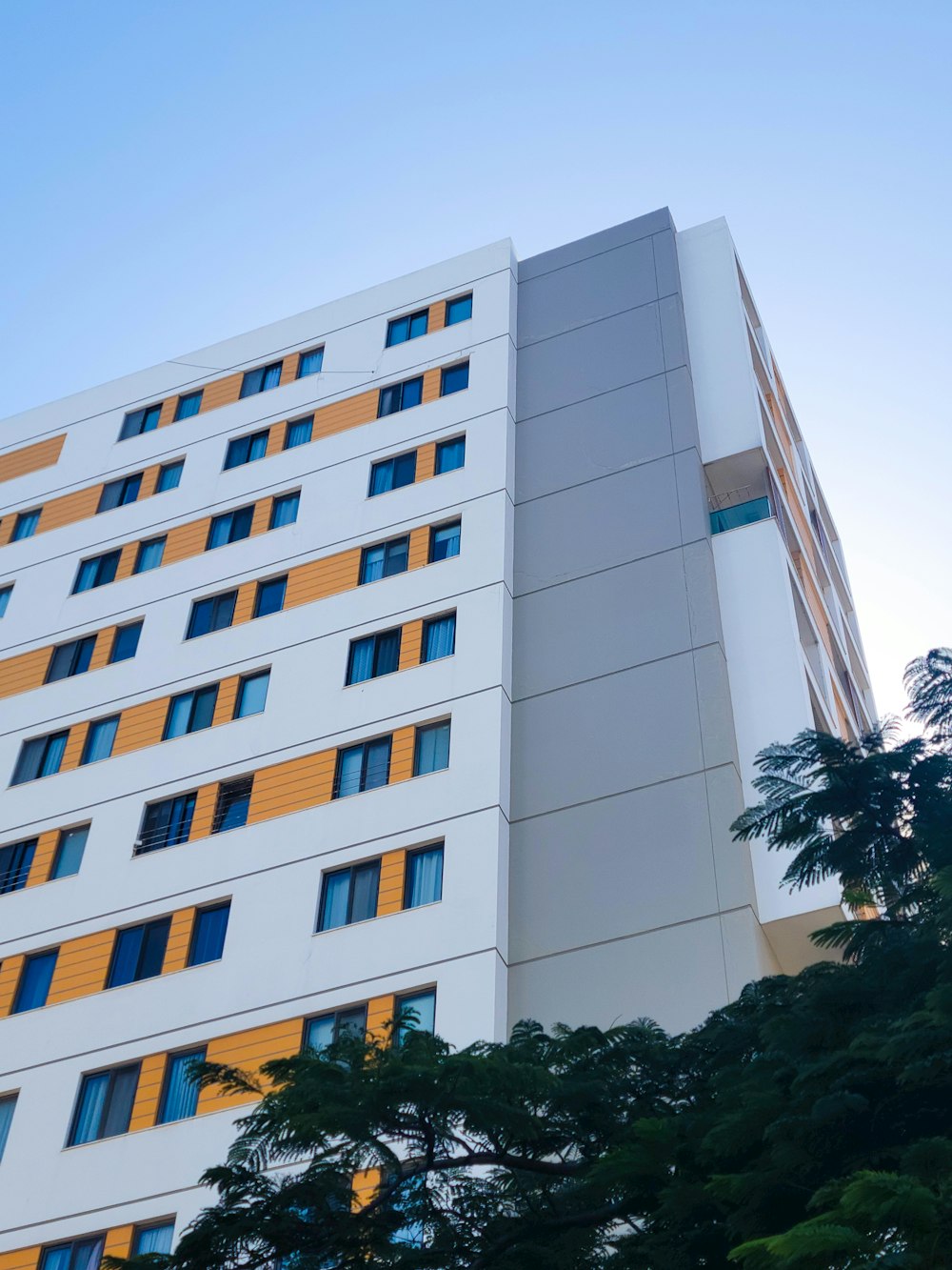 a tall white building with yellow and blue windows