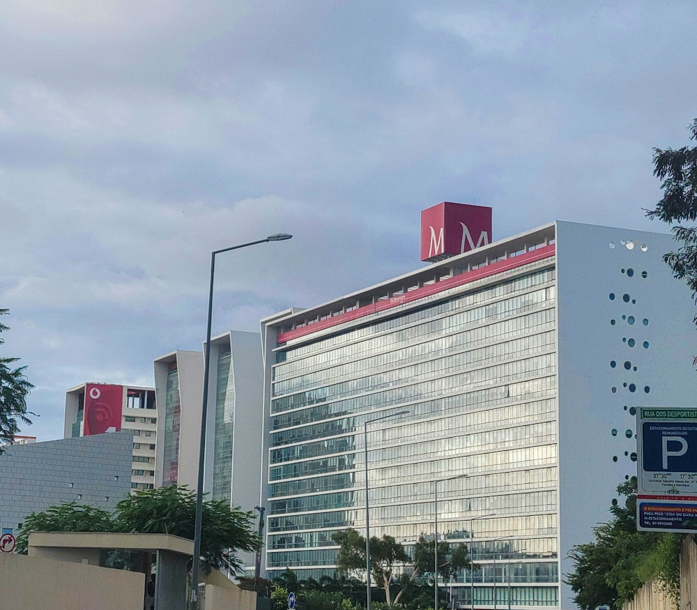 Un edificio alto con un letrero rojo en la parte superior