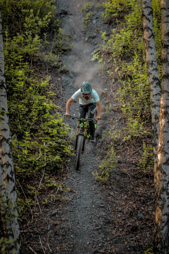 a man riding a bike down a forest trail