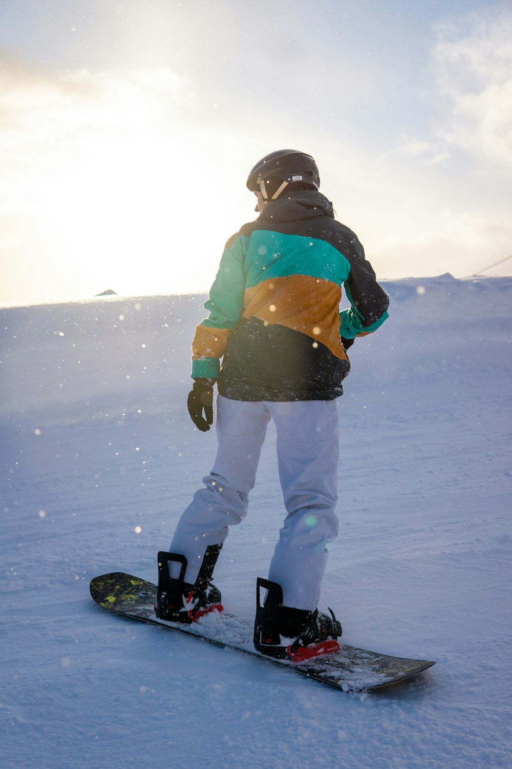 a person standing on a snowboard in the snow