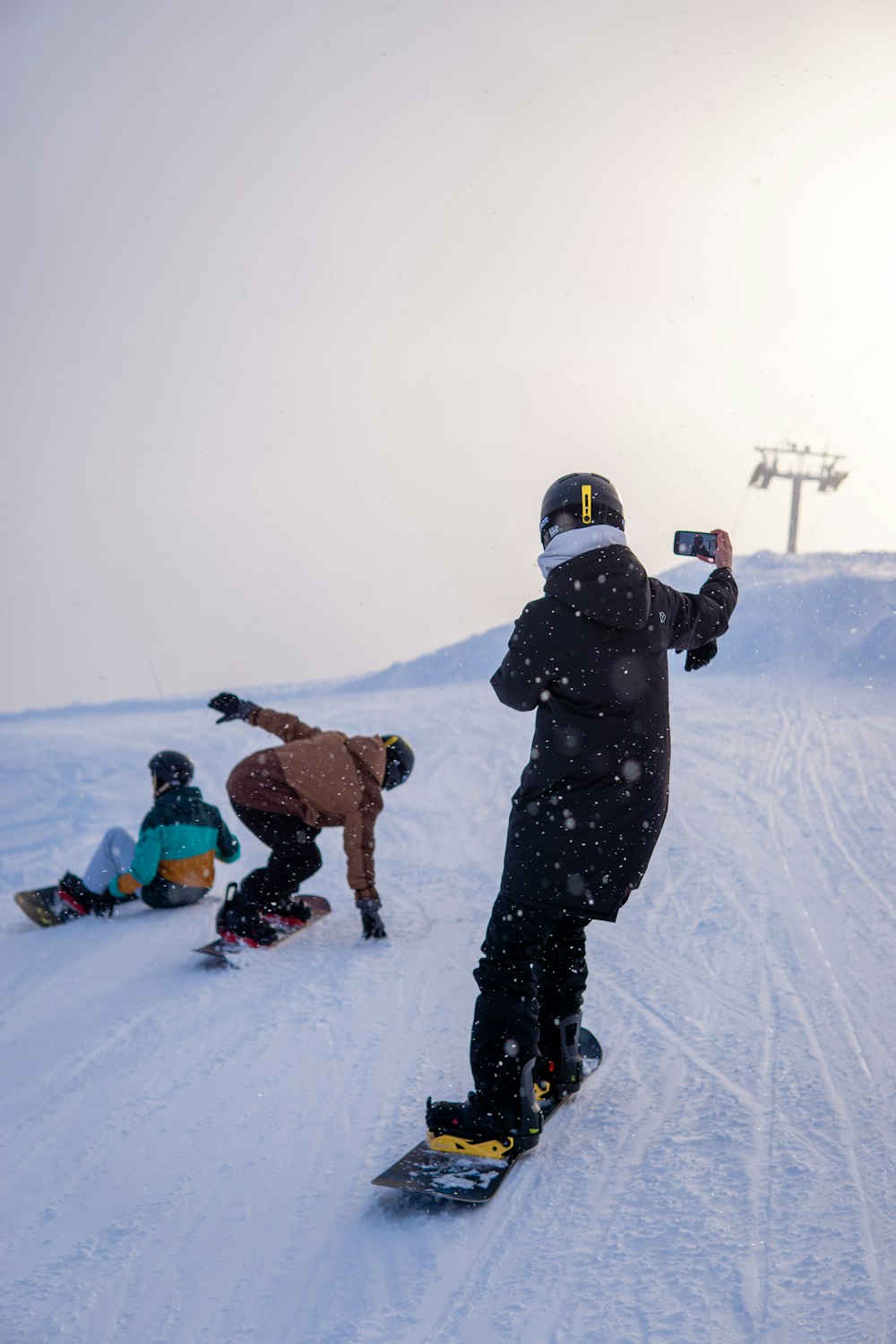 a man riding a snowboard down a snow covered slope