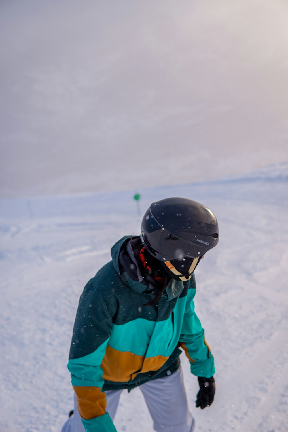 a man riding a snowboard down a snow covered slope